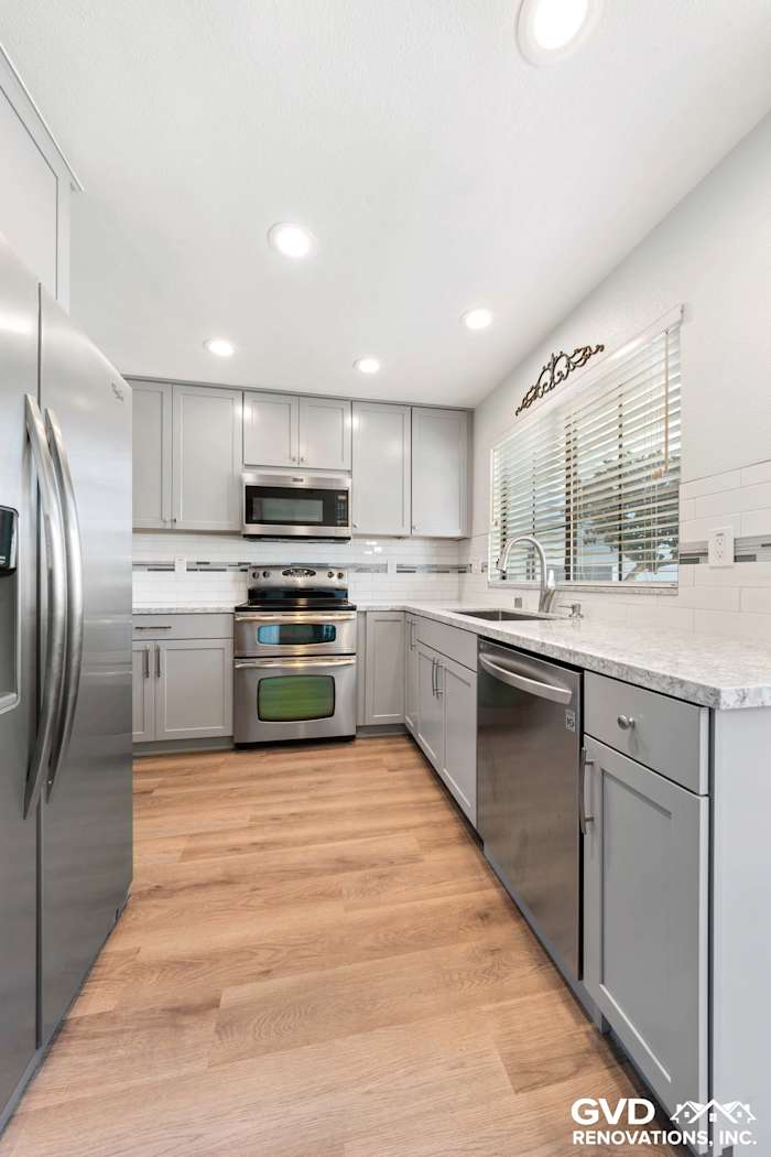 Bright kitchen remodel featuring stainless steel appliances, gray cabinetry, and quartz countertops in Carmichael, CA