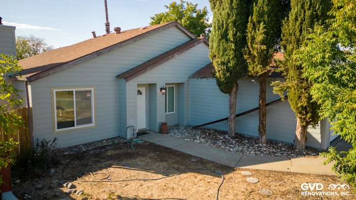 Home exterior featuring James Hardie Lap Siding in light blue, landscaped front yard, and modern entryway
