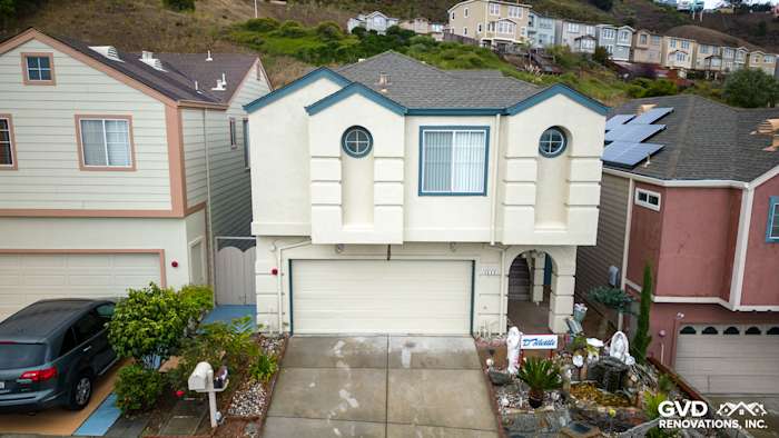 Daly City home featuring James Hardie Evening Blue siding, unique architectural details, and landscaped driveway