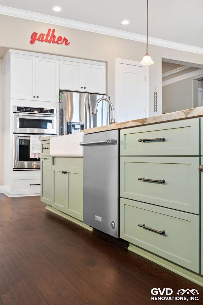 Modern kitchen renovation featuring light green cabinetry, stainless steel appliances, and dark wood flooring in El Dorado