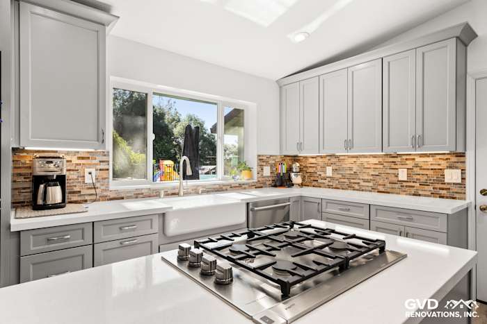 Modern kitchen remodel in Greenwood featuring gray cabinetry, quartz countertops, and stacked stone backsplash