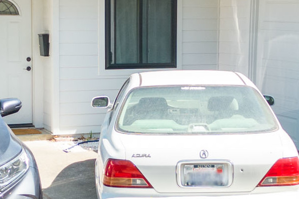 Renovated home exterior featuring James Hardie siding in Arctic White with driveway and parked cars