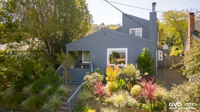 Corte Madera home featuring James Hardie Evening Blue siding and Arctic White trim with lush landscaping
