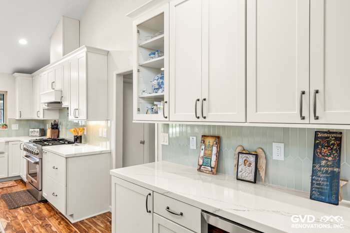Bright, modern kitchen with custom white cabinetry, gray quartz countertops, and teal subway tile backsplash