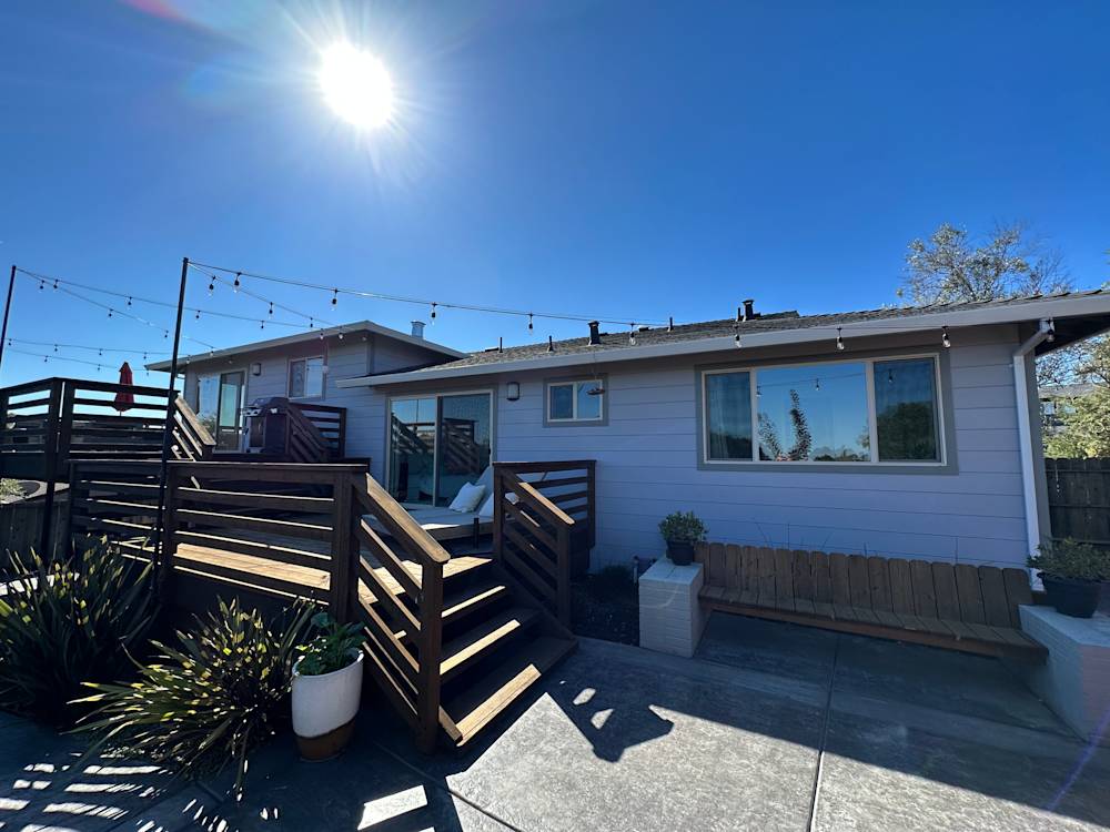 Outdoor living area with wooden deck, modern patio furniture, and clear blue sky in Sacramento