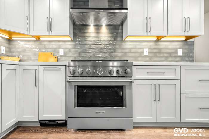 Modern kitchen featuring stainless steel range, gray cabinetry, and glass tile backsplash in Rocklin, CA