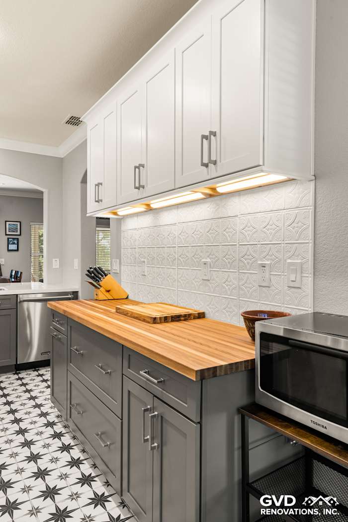 Modern Folsom kitchen remodel featuring gray cabinetry, butcher block countertops, and patterned black-and-white tile