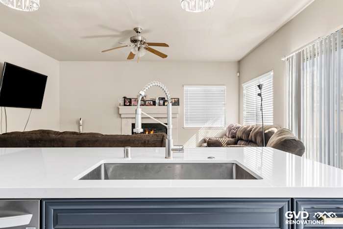 Modern kitchen island with quartz countertop, stylish faucet, and view of living area in Sacramento remodel