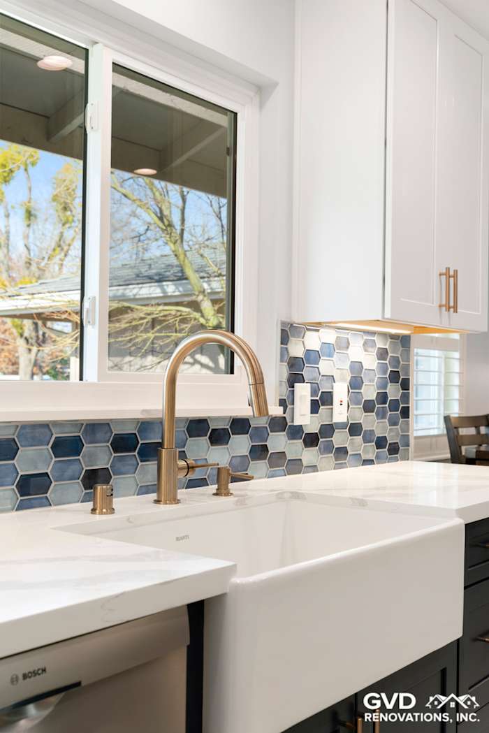 White farmhouse sink with bronze faucet, hexagonal blue backsplash, and modern cabinetry in remodeled Sacramento kitchen