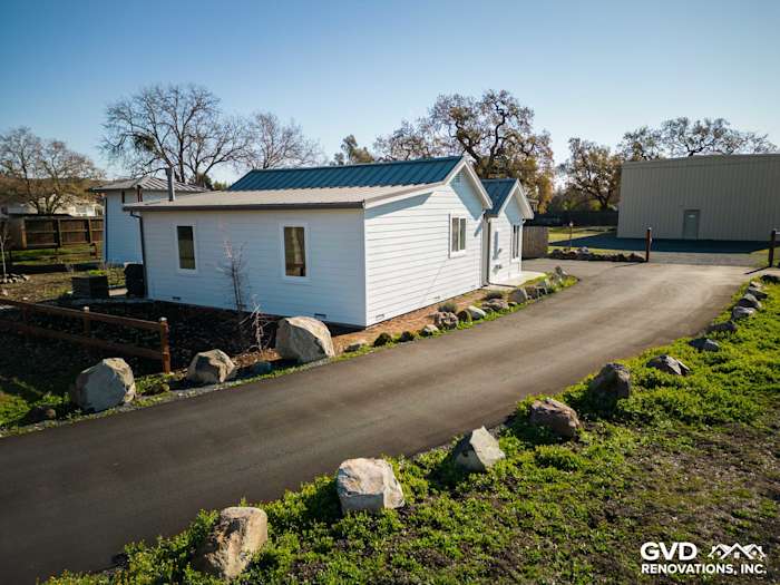 Arctic White James Hardie siding installed on a home exterior in Sonoma, featuring a landscaped driveway and rocky borders