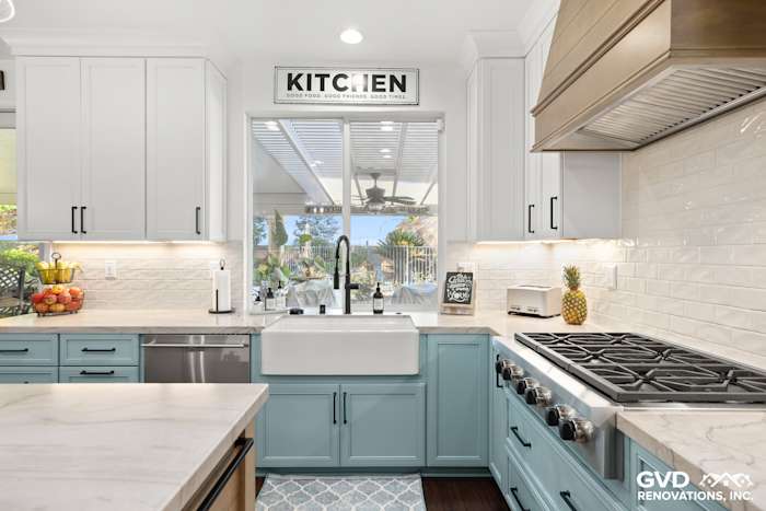 Light blue cabinetry with farmhouse sink, quartzite countertops, and stainless steel appliances in Roseville kitchen remodel