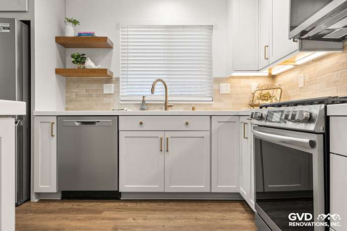 Modern kitchen in Roseville, featuring Waypoint painted cabinetry, Vadara Naurelle stone countertops, and floating shelves