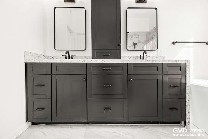 Modern double sink vanity with black cabinetry, white granite countertop, and mirrors in remodeled Sacramento bathroom