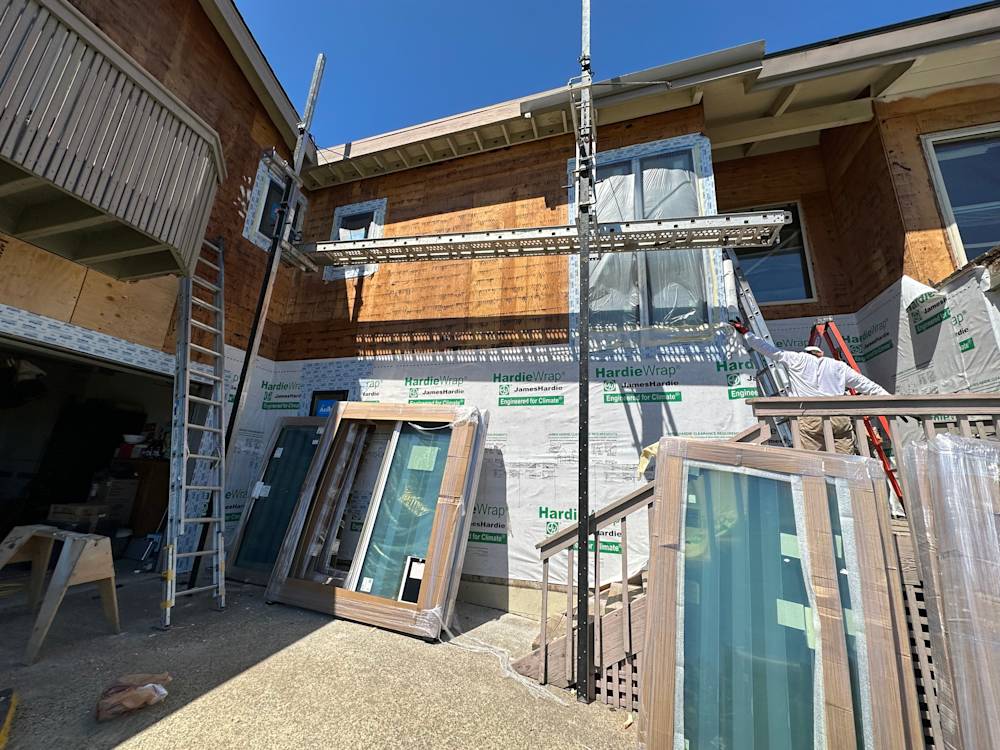 Home exterior in Sacramento with scaffolding, wood accents, and new windows pre-installation
