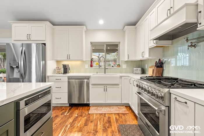 Modern kitchen remodel in Carmichael featuring white cabinetry, stainless steel appliances, and a teal backsplash