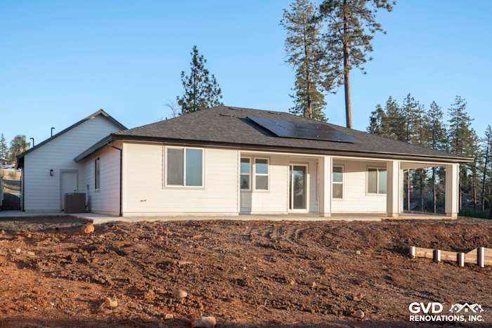 New construction home exterior in Paradise, CA featuring James Hardie Board and Batten siding, large windows, and solar