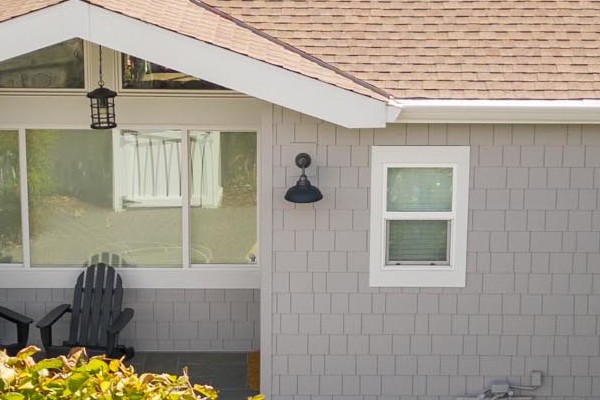 Pearl Gray James Hardie shingle siding with Arctic White trim on a Mill Valley home, surrounded by lush landscaping