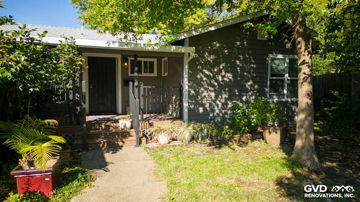Home exterior featuring Alside Prodigy vinyl siding in dark gray and Milgard windows, with lush landscaping in Carmichael