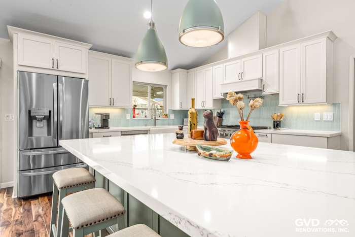 Modern kitchen remodel featuring a large quartz island, custom cabinets, and stylish pendant lighting in Carmichael, CA
