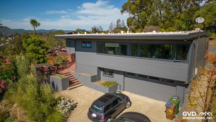 Modern home exterior featuring James Hardie Plank Lap Siding in Night Gray, with a landscaped yard and deck