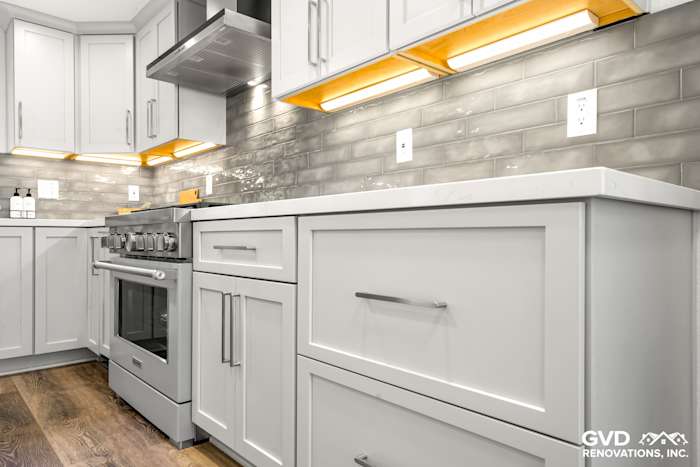 Modern kitchen with gray subway tiles, white cabinetry, quartz countertops, and stainless steel appliances in Rocklin, CA