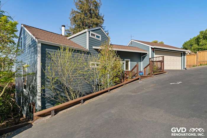 Home exterior featuring James Hardie lap siding in blue with a new garage and driveway in Oakland, CA