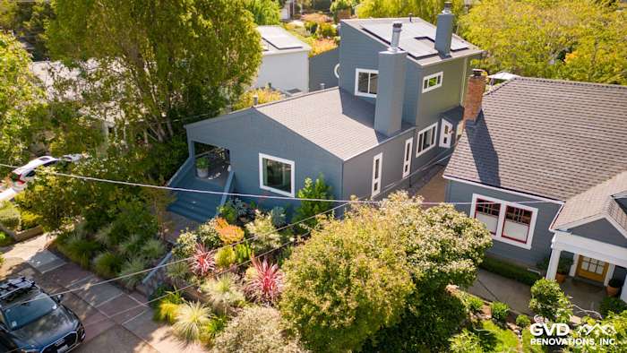 Corte Madera home exterior featuring Evening Blue James Hardie siding and Arctic White trim, surrounded by lush landscaping