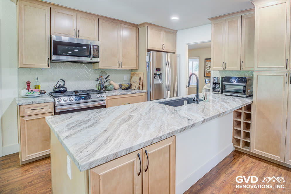 Modern kitchen featuring warm wood cabinetry and stunning marble countertops