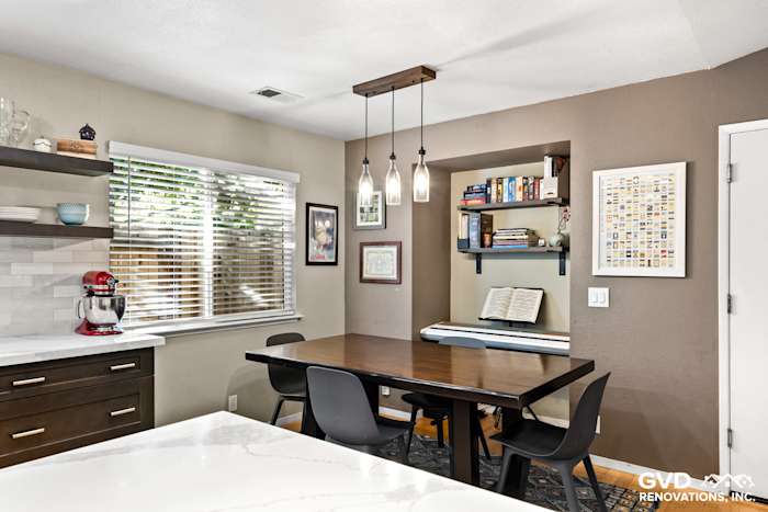 Modern kitchen remodel in Davis featuring stained wood dining table, pendant lights, and open shelving