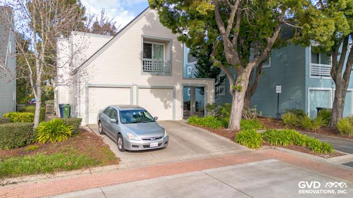 Updated home exterior featuring light gray James Hardie siding, new Milgard windows, and a paved driveway in Fremont, CA