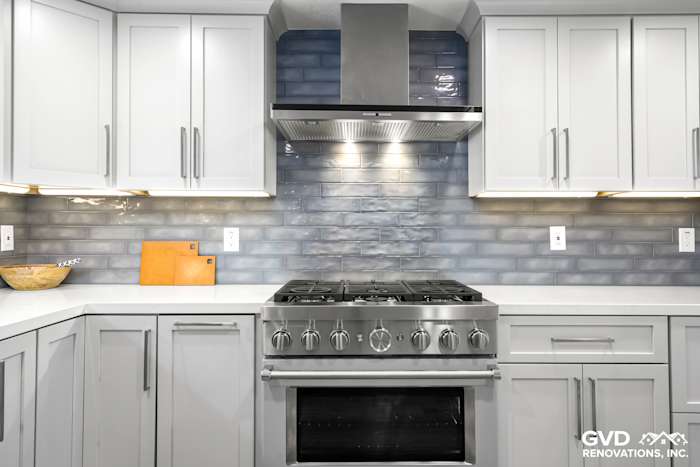 Modern kitchen with gray cabinetry, stainless steel range, and textured backsplash in Rocklin, CA