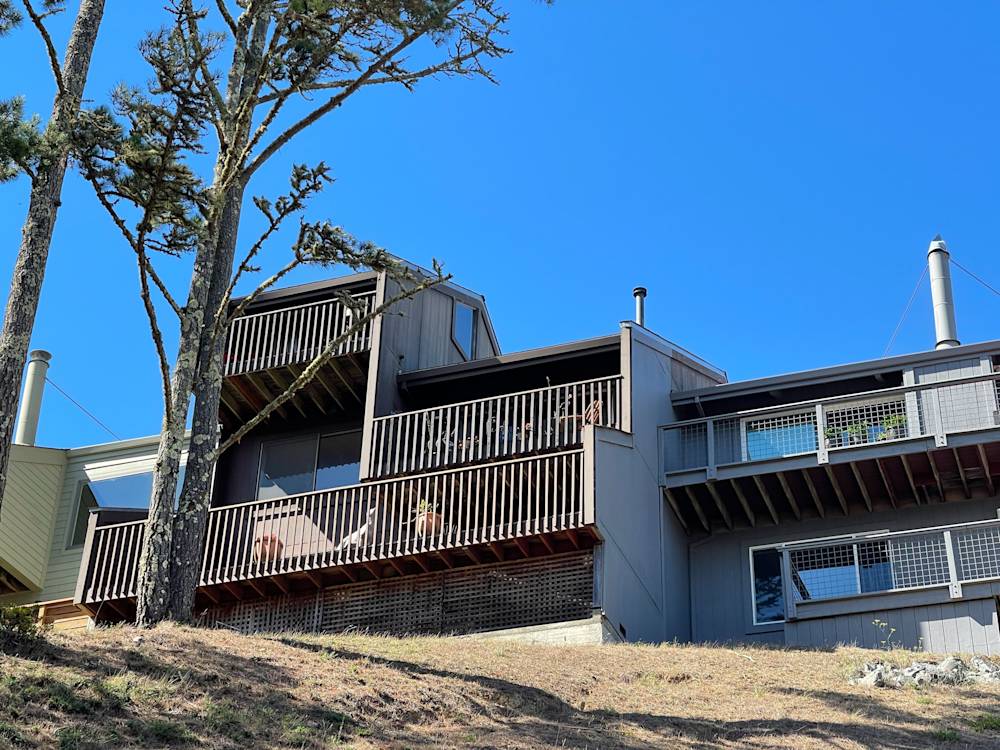 Multi-level home with wooden balconies and large windows in a sunny Sacramento setting
