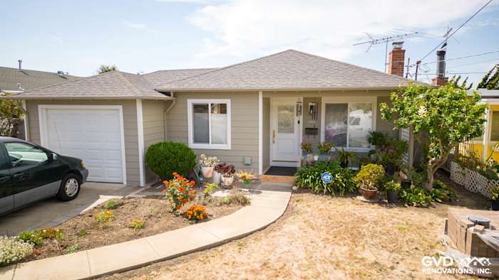 Home exterior featuring James Hardie Lap Siding in Monterey Taupe and Arctic White trim with landscaped front garden
