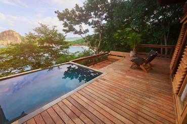 Spacious wooden deck with pool overlooking lush greenery and scenic views, ideal for outdoor gatherings