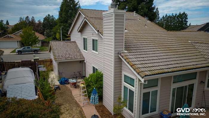 Home exterior in Roseville featuring Craneboard vinyl siding and a new roof, surrounded by landscaping