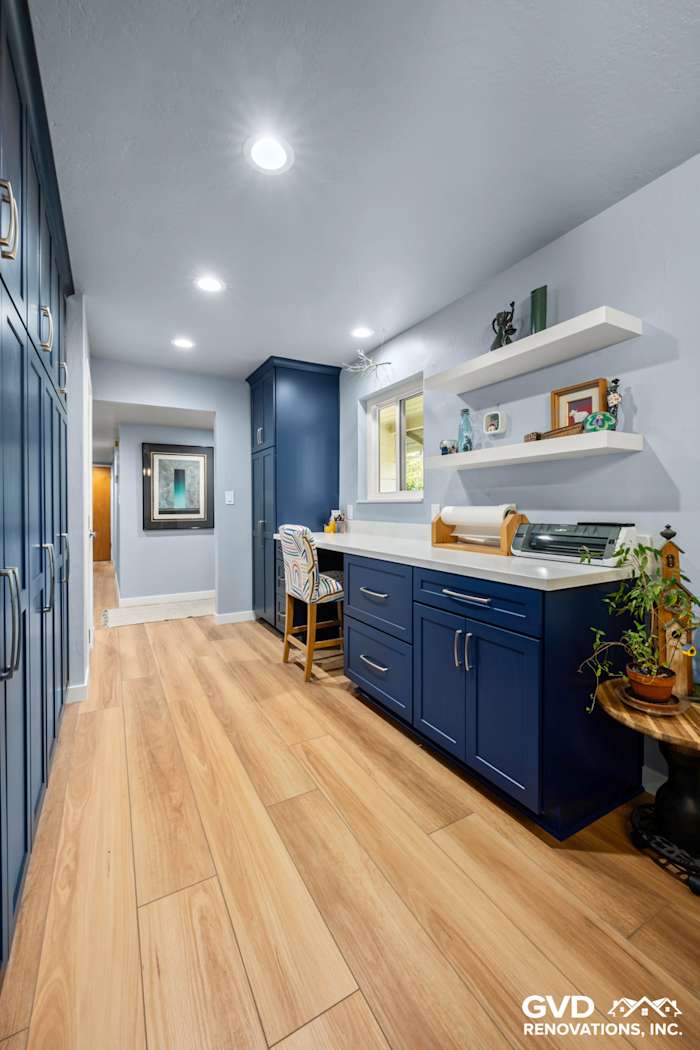 Modern kitchen with blue cabinetry, wooden flooring, and open shelving in Fair Oaks, CA