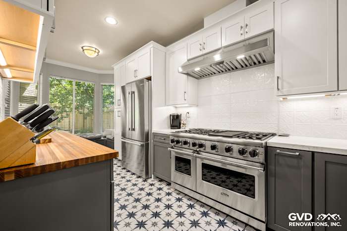 Modern kitchen remodel in Folsom with stainless steel appliances, white cabinetry, and patterned tile flooring