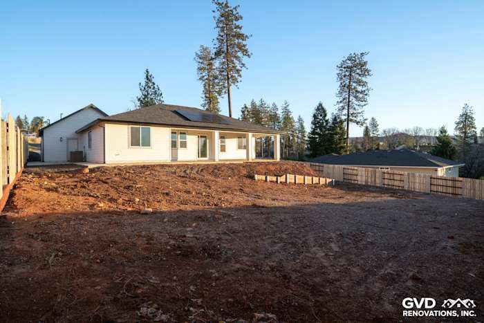 Custom-built home exterior in Paradise, CA, featuring a spacious yard and foundation framing, with new landscaping