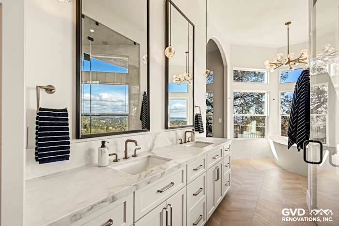 Luxurious El Dorado Hills bathroom featuring dual sinks, marble countertops, and large windows with a scenic view