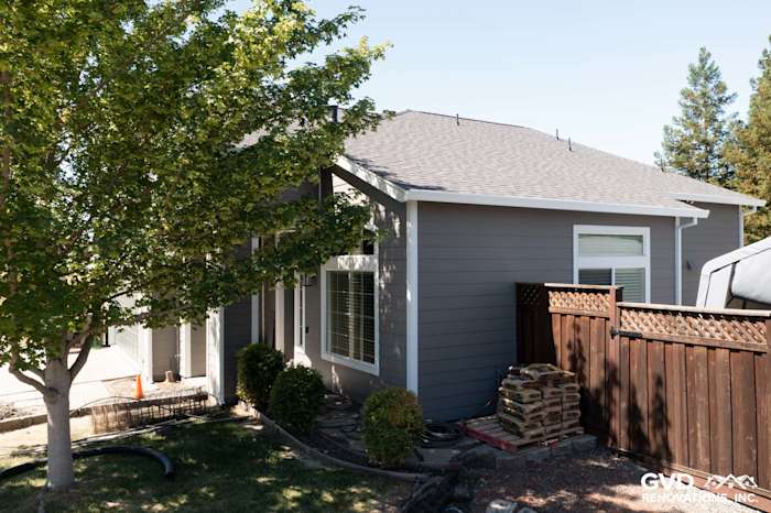 Home exterior renovation with James Hardie Night Grey siding, Arctic White trim, and new vinyl windows in Petaluma