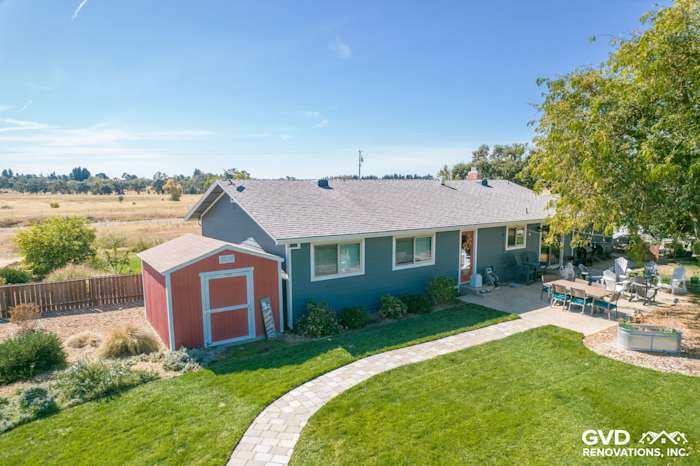Remodeled home exterior with dark blue siding, new roof, and landscaped yard in Wilton, CA
