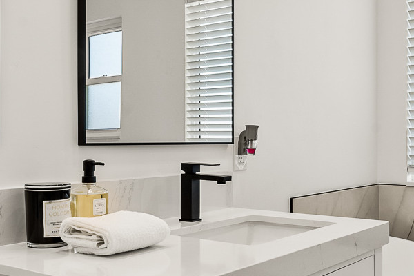Modern bathroom featuring a freestanding tub, dual vanities, and sleek mirrors in Antelope, CA