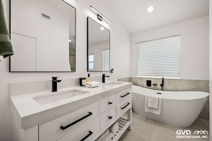 Modern bathroom featuring a freestanding tub, dual vanities, and sleek mirrors in Antelope, CA