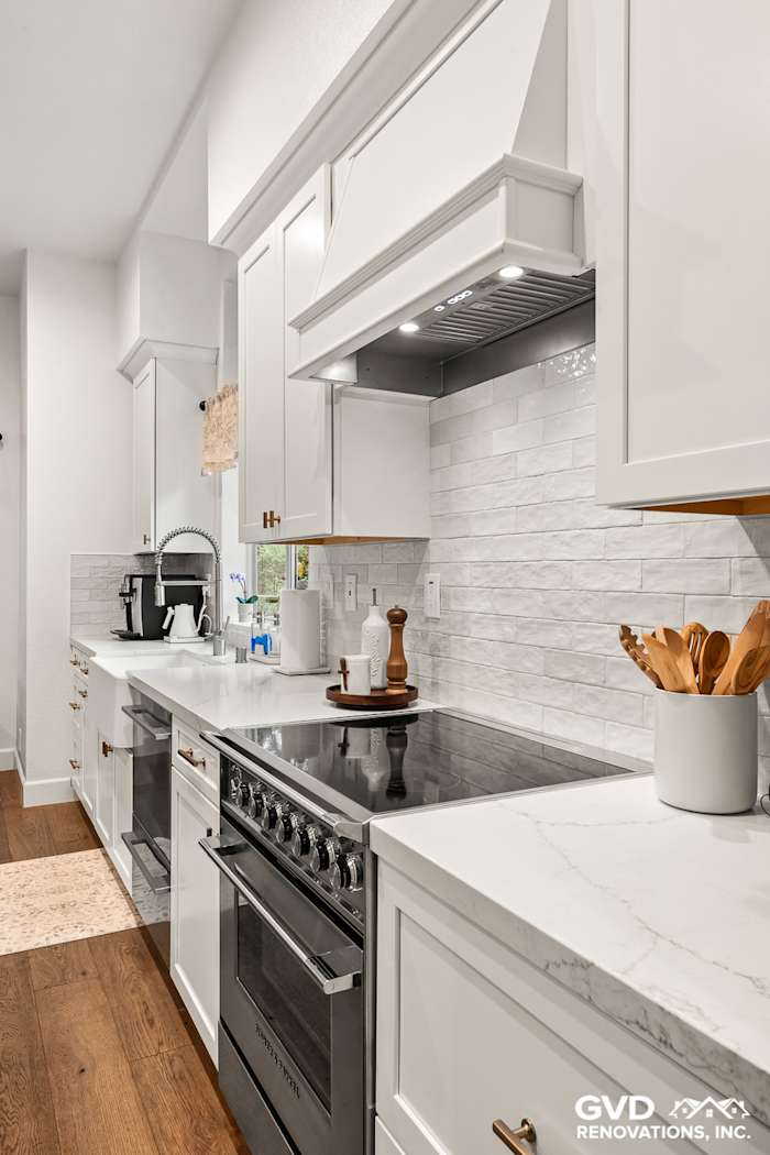 Modern kitchen with white Waypoint cabinets, Vadara Bronzo countertops, and subway tile backsplash in Folsom remodel
