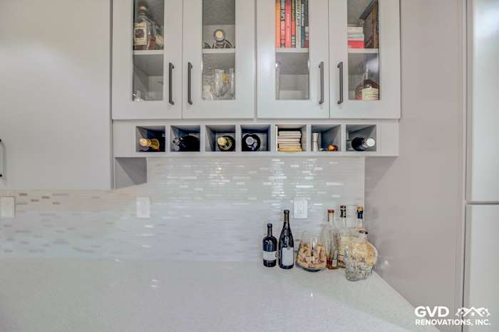 Modern kitchen with quartz countertops, glass-front cabinets, and decorative backsplash in Sacramento remodel