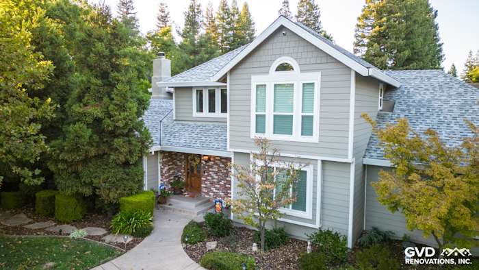 Home exterior featuring James Hardie Monterey Taupe siding with Arctic White trim and stone accents in Fair Oaks