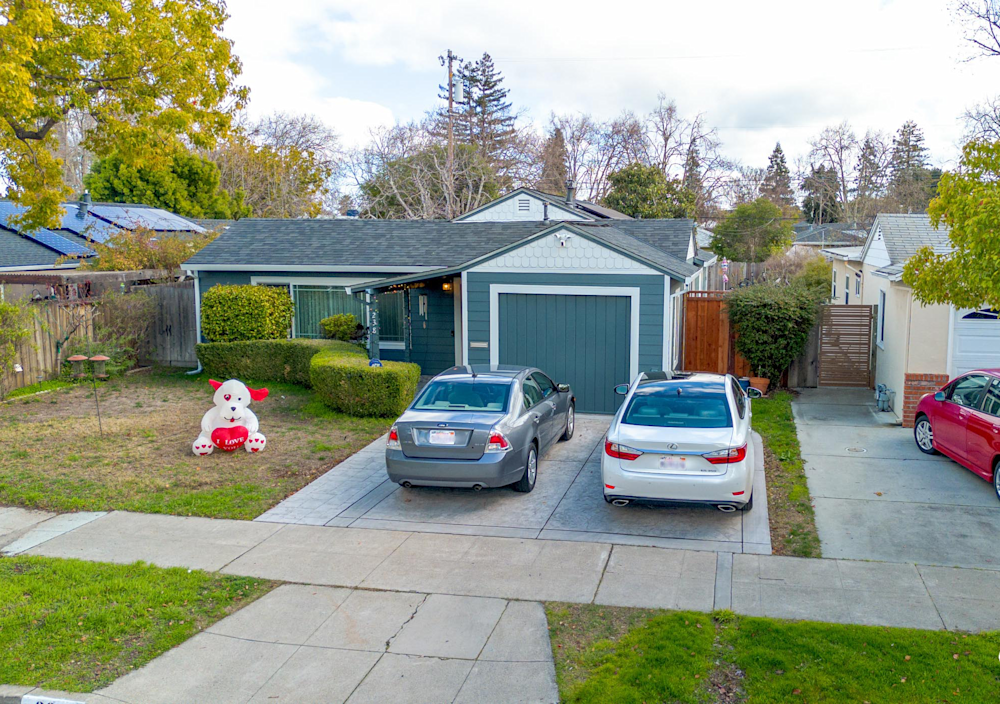 Freshly remodeled garage with bold green siding and tidy yard in Sacramento