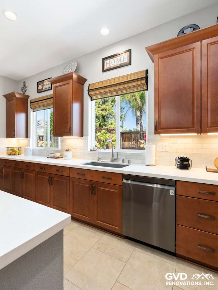 Modern kitchen remodel in Elk Grove with rich wood cabinets, white countertops, and stainless steel appliances