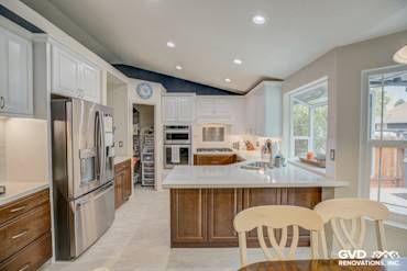 Modern kitchen remodel featuring white shaker cabinets, quartz countertop, stainless steel appliances, and a bright window