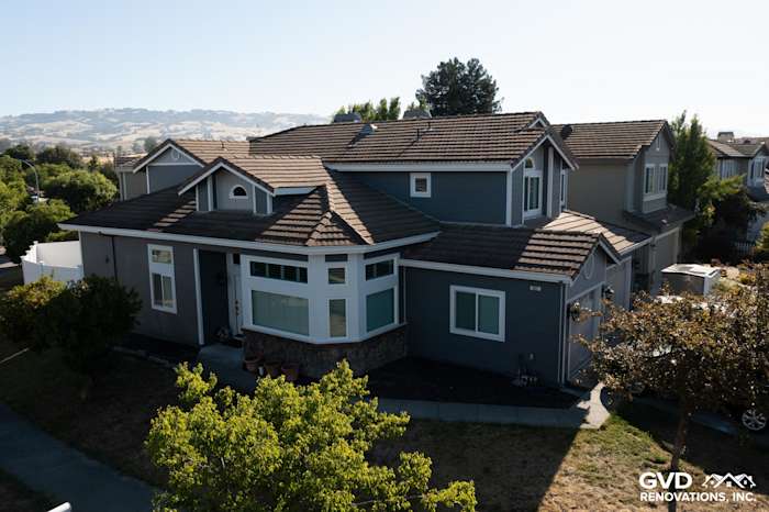 Home exterior showcasing James Hardie Night Gray lap siding, Pearl Gray shingle accents, and new vinyl windows